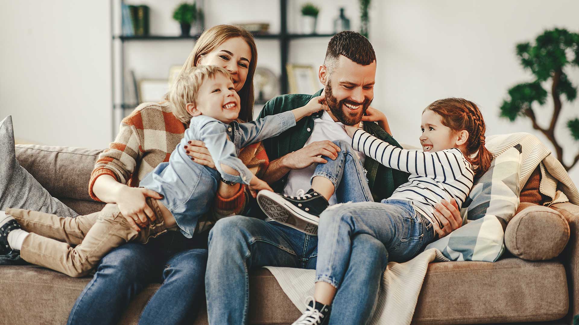 Smiling family relaxing together on a couch at home